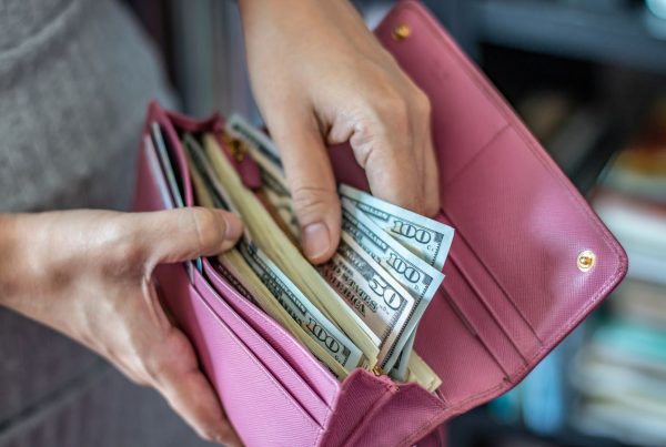 Women taking out dollar bills in wallet