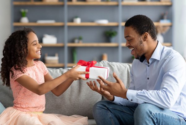 A little girl giving her dad a Father's Day gift