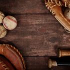 Image of Baseballs, gloves and bats on a wood background