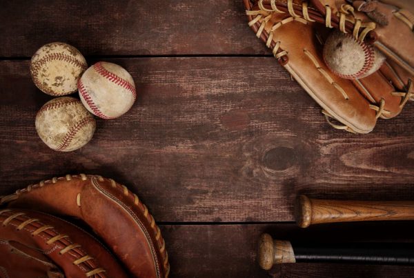 Image of Baseballs, gloves and bats on a wood background