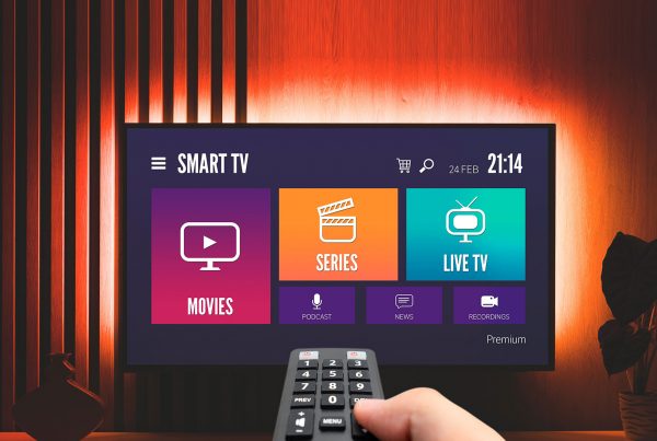 Hand holding remote pointing at Smart TV