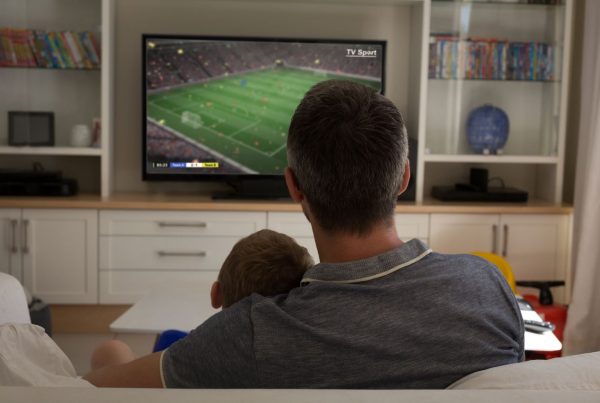 Father and Son at home watching sports on TV