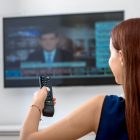 Woman watching the news at home on TV