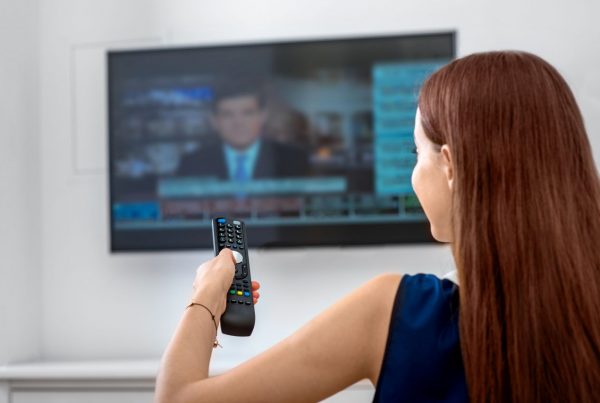Woman watching the news at home on TV
