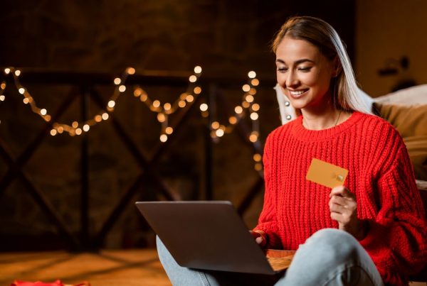 woman holiday shopping with on laptop with credit card in hand